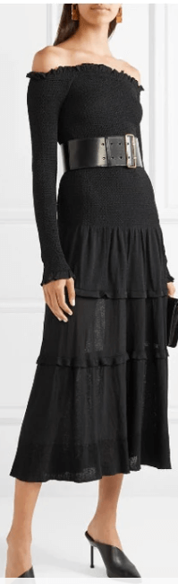 A long-sleeved, knee-length dress in a dark or subdued color with black shoes
